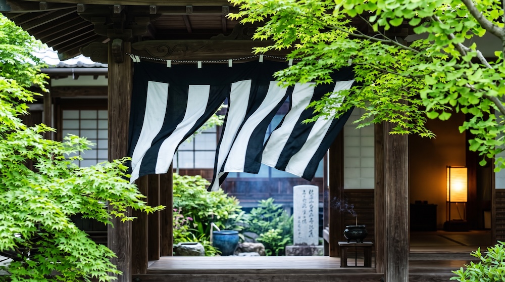 寺院の境内で風に揺れる白黒の鯨幕